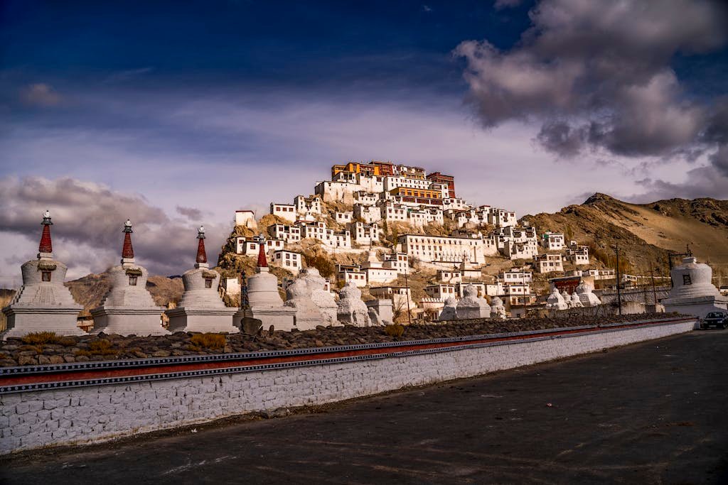 Scenic landscape of a Tibetan monastery with striking architecture against a dramatic sky.