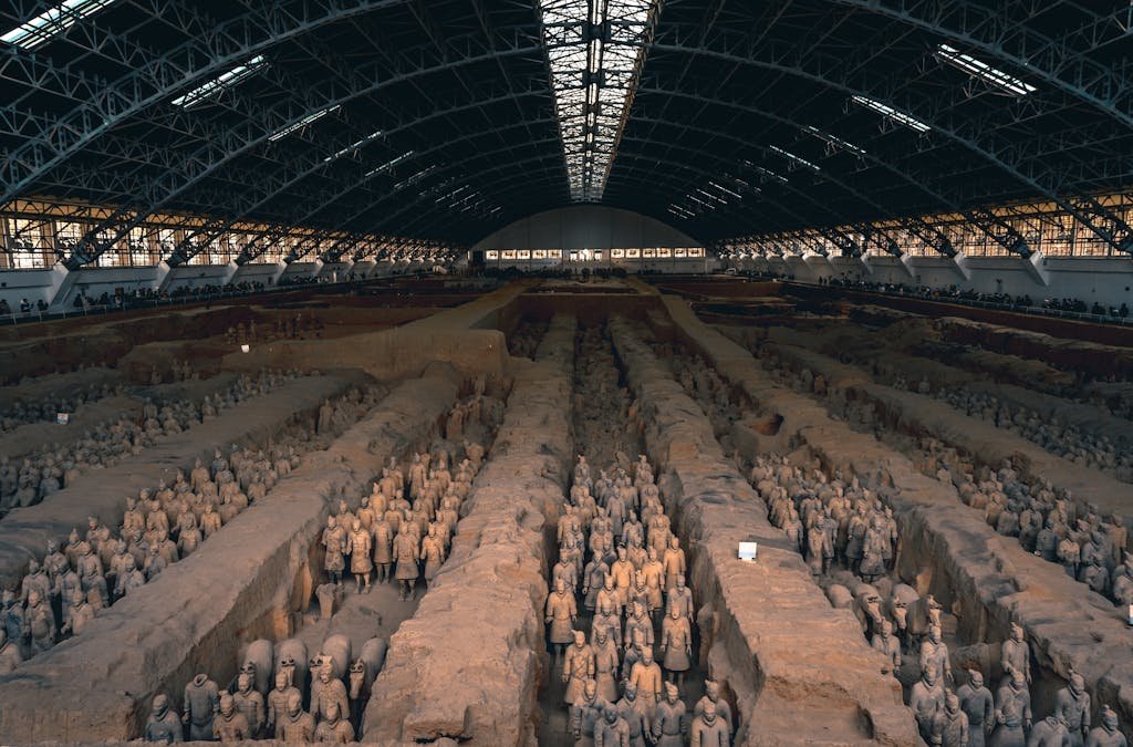 The iconic Terracotta Army in Xi'an, China, displayed within a grand indoor museum setting.